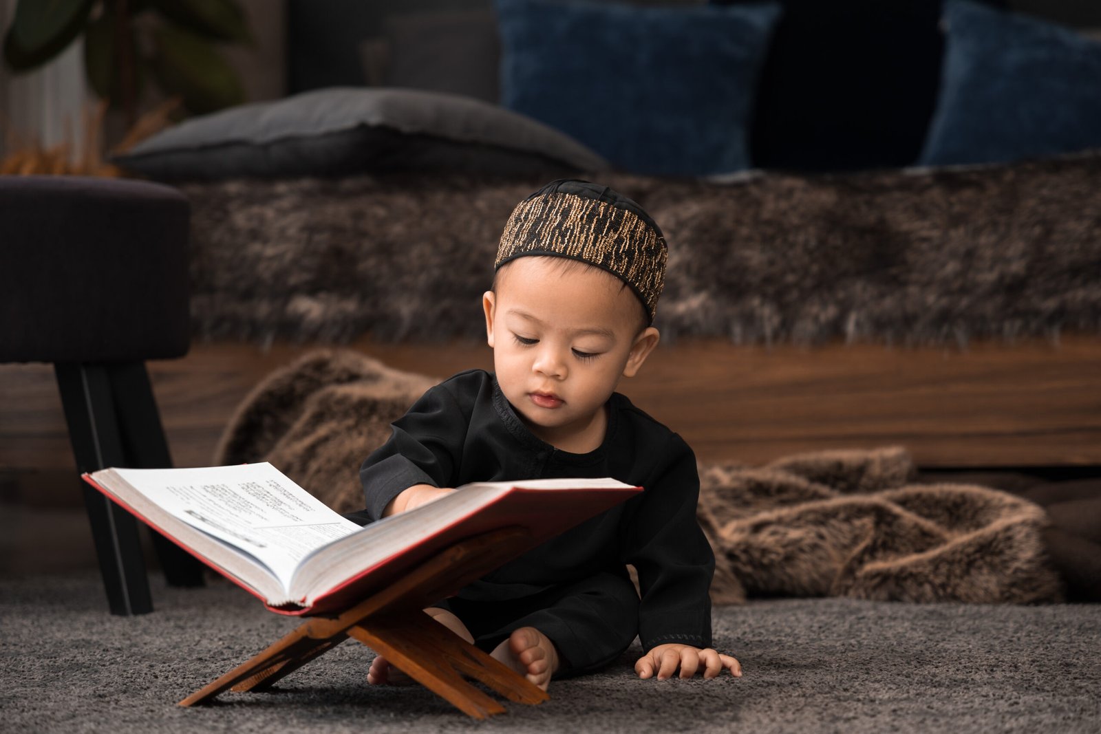 The Quran. The Holy book of Muslims. Asian boy kid reading the Islamic Qur'an or Koran against the dark background to close to the teachings of Prophet or God. religion and faith